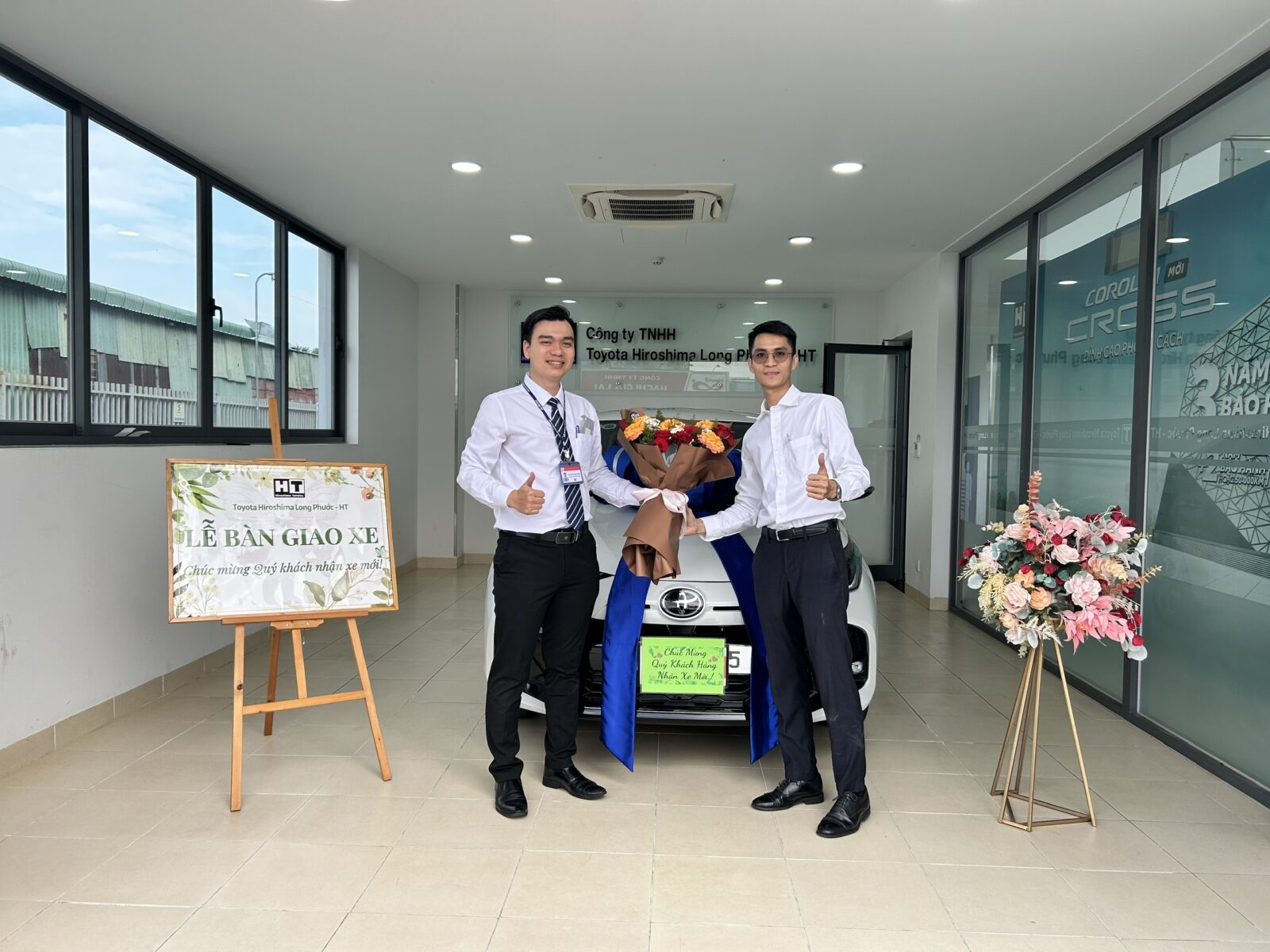 two men standing next to a car
